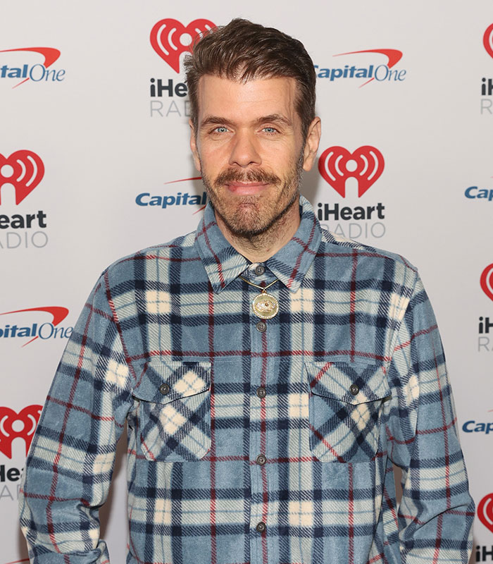 Perez Hilton crisis deepens, looking serious in a plaid shirt with a gold medallion. Perez Hilton crisis deepens, looking serious in a plaid shirt with a gold medallion.