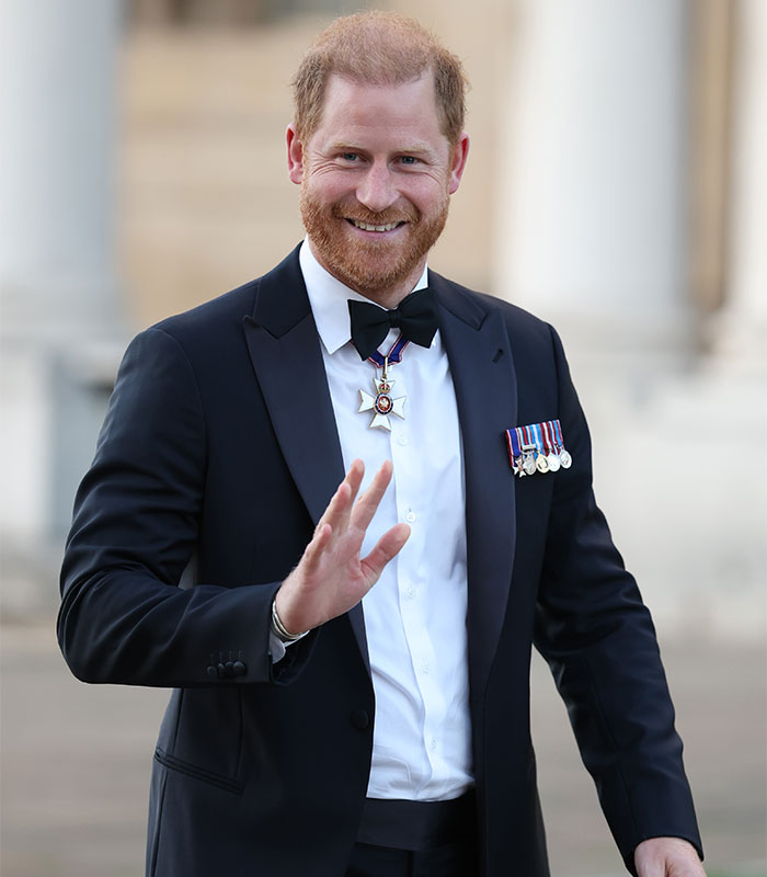 Prince Harry in a tuxedo, smiling and waving, after backlash over his kids' schooling decisions.