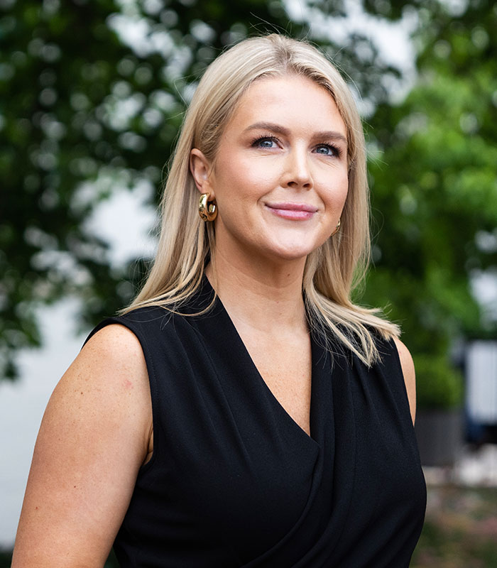 A professional outdoor portrait of Karoline Leavitt wearing a sleeveless black top A professional outdoor portrait of Karoline Leavitt wearing a sleeveless black top