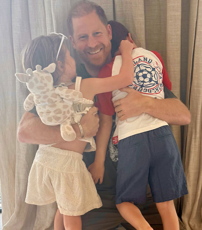 Prince Harry hugging his kids, smiling, amid discussions about their schooling and recent changes.