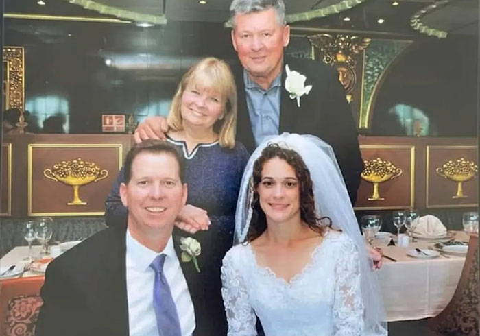 A California father and his wife smile during their wedding ceremony with parents nearby