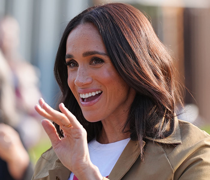 Meghan Markle waves, smiling broadly, amid discussions of her UK home demands. Meghan Markle waves, smiling broadly, amid discussions of her UK home demands.