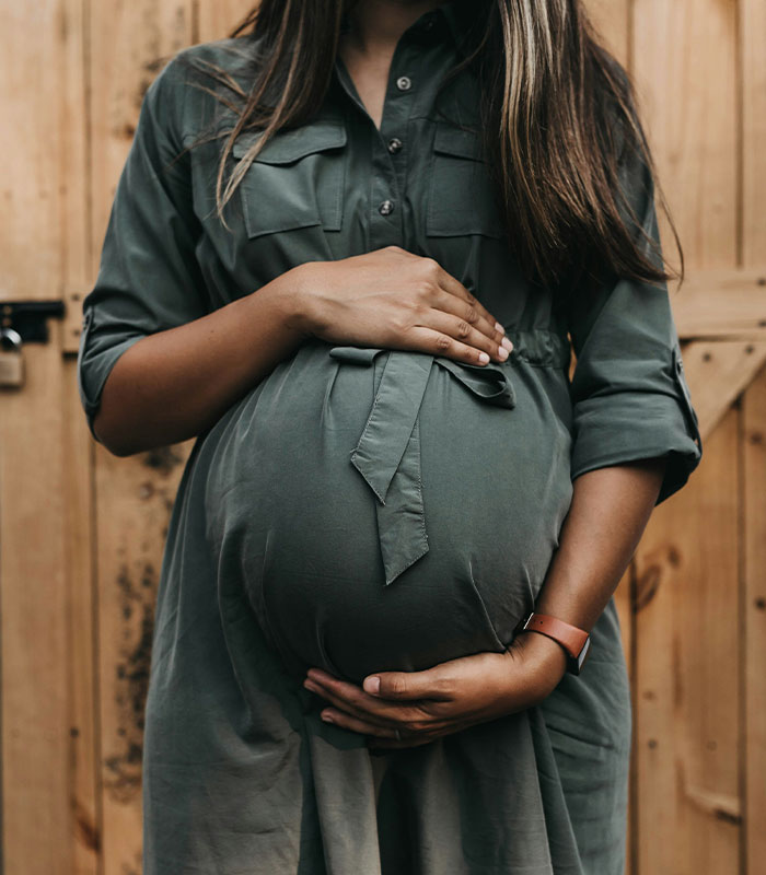 A pregnant woman, a surrogate, with her hands on her belly, representing surrogacy. A pregnant woman, a surrogate, with her hands on her belly, representing surrogacy.