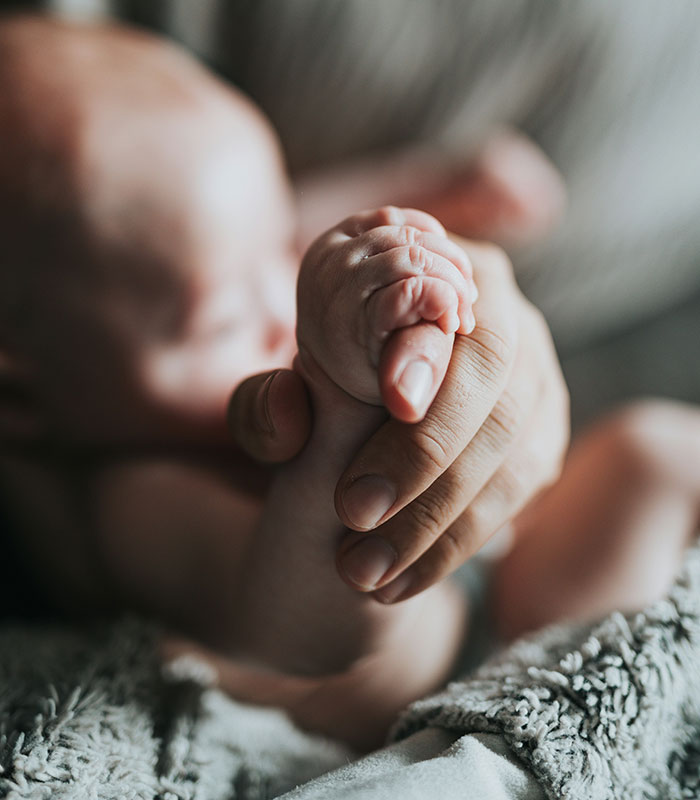 Close-up of a baby's tiny hand holding an adult's finger after Lena Dunham welcomed a baby via surrogate. Close-up of a baby's tiny hand holding an adult's finger after Lena Dunham welcomed a baby via surrogate.