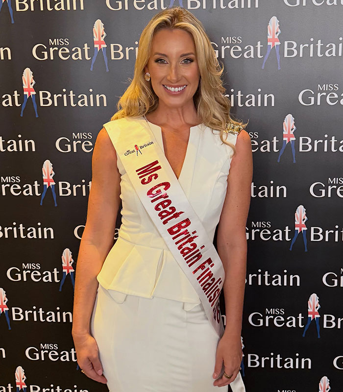 A woman in a white dress and Ms Great Britain Finalist sash, sparks outrage. A woman in a white dress and Ms Great Britain Finalist sash, sparks outrage.