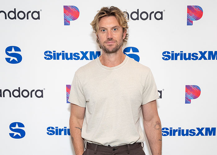 Hollywood actress stands in front of a white backdrop with SiriusXM and Pandora logos.