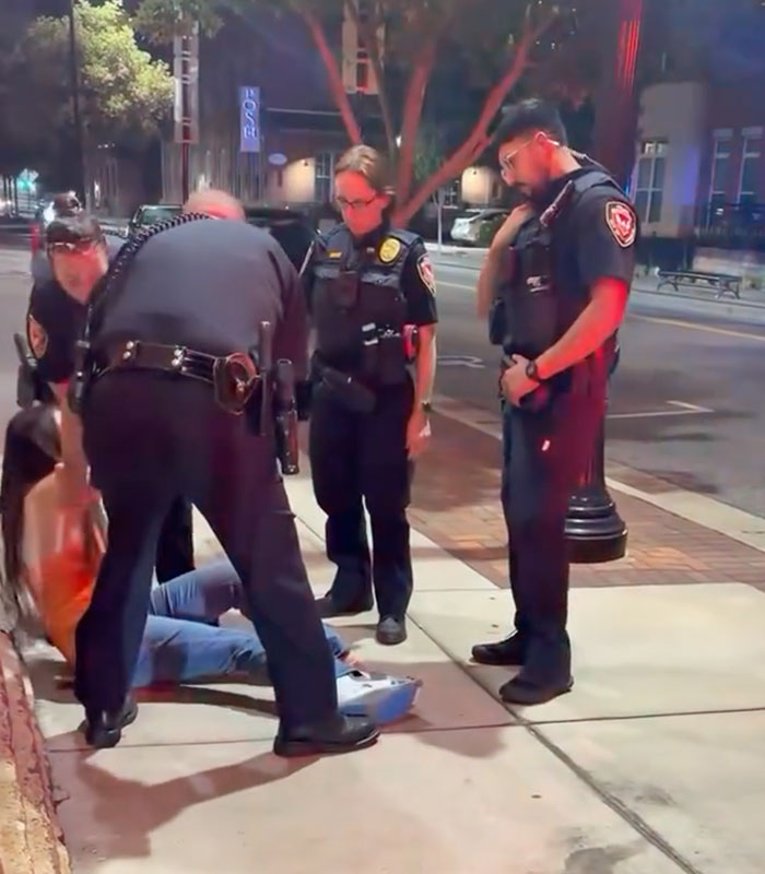 Police officers detaining a woman on the street as she learns her actions have consequences. Police officers detaining a woman on the street as she learns her actions have consequences.