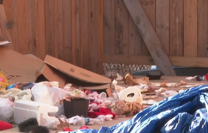 Trash and debris scattered on floor in dingy basement setting Trash and debris scattered on floor in dingy basement setting