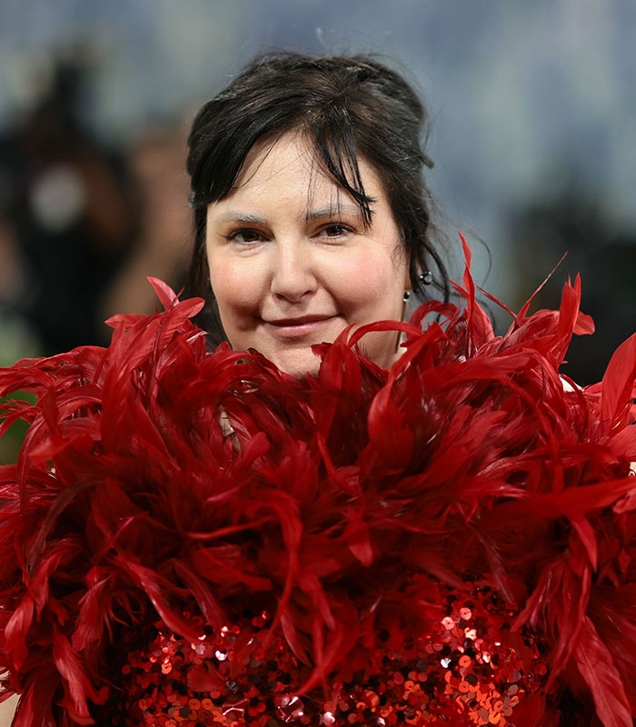 Lena Dunham smiling in a red feathered top, facing furious backlash for welcoming a baby via surrogate. Lena Dunham smiling in a red feathered top, facing furious backlash for welcoming a baby via surrogate.