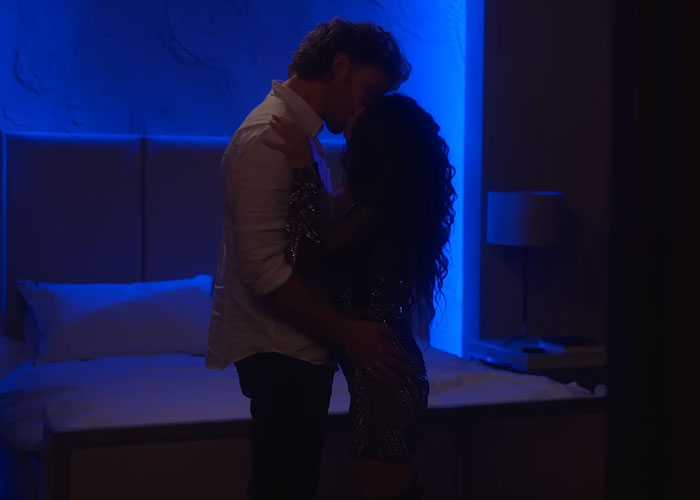 A couple embracing in an intimate scene, filmed with blue lighting, revealing the magic of Hollywood.