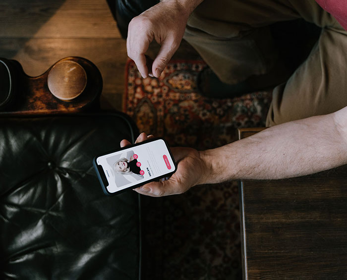 A person swiping on a profile, illustrating dating mistakes on an app. A person swiping on a profile, illustrating dating mistakes on an app.