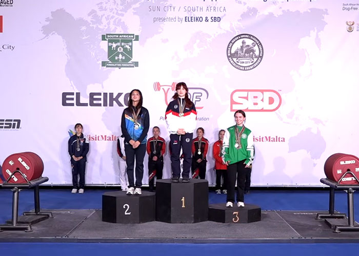 Three female weightlifting medalists on a podium, with the champion in the center, at a competition. Three female weightlifting medalists on a podium, with the champion in the center, at a competition.