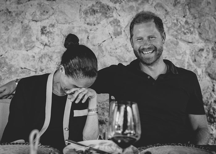 Harry laughing, Meghan smiling and covering her face, after Harry and Meghan’s controversial UK return. Harry laughing, Meghan smiling and covering her face, after Harry and Meghan’s controversial UK return.