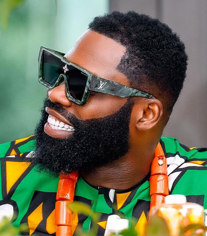 Influencer smiling with a beard and sunglasses, representing the topic of male cosmetic procedure.