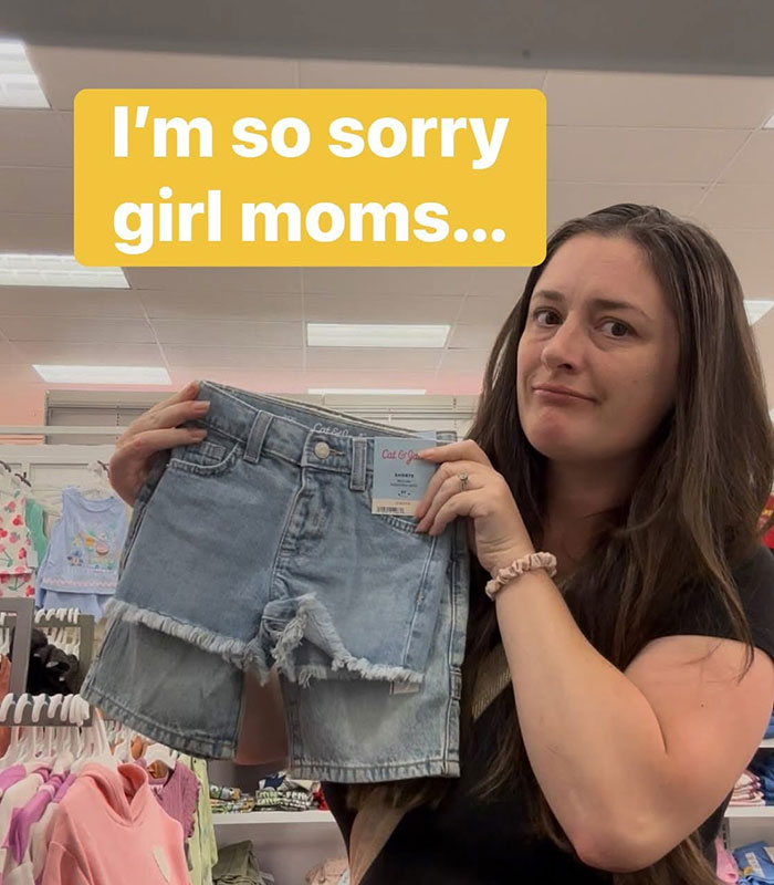 Viral mom expresses concern while holding girls' t-shirt and shorts, advocating for appropriate messages. Viral mom expresses concern while holding girls' t-shirt and shorts, advocating for appropriate messages.