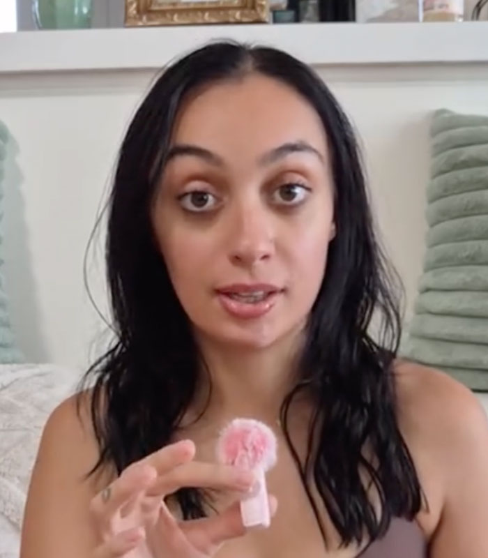 Close-up of a woman with autism and ADHD, holding a pink microphone, discussing her decision not to work.