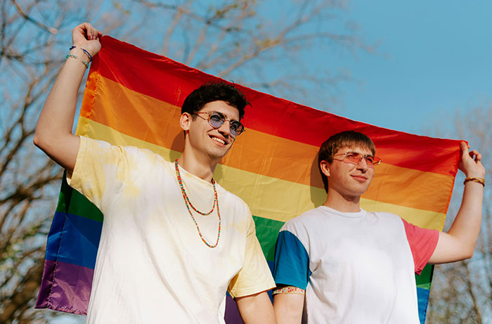 Two male teens holding a pride flag, representing support for a closeted teen.