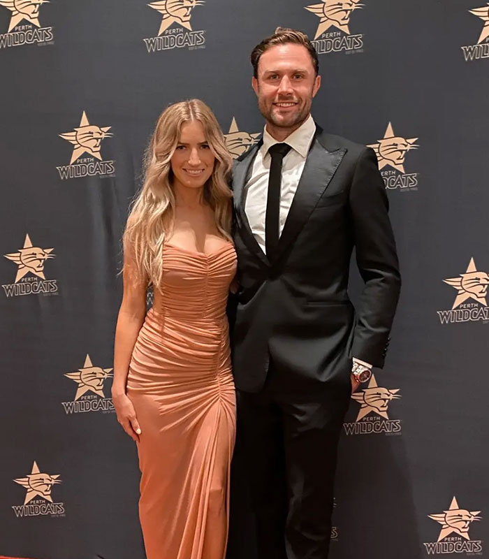 Star athlete and wife posing at event representing their public appearance
