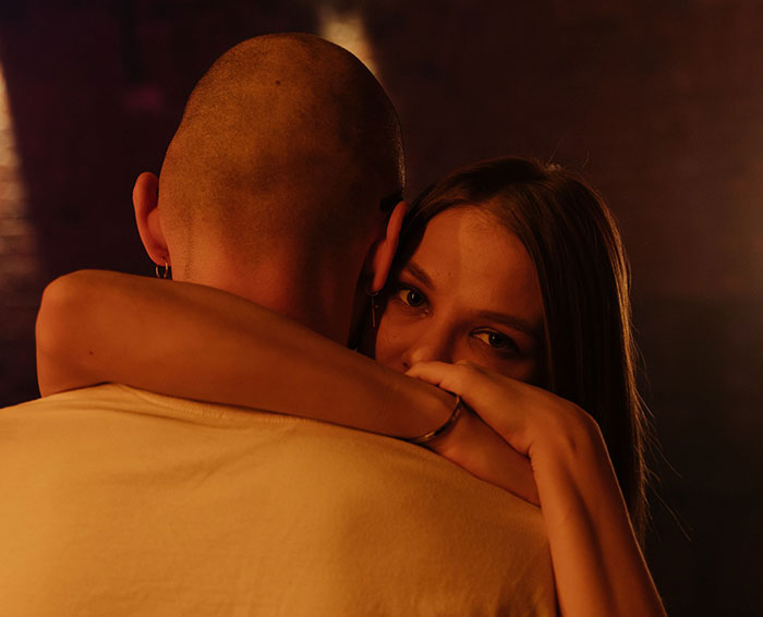 A close embrace of a couple under warm lighting, discussing relationship building and dating mistakes. A close embrace of a couple under warm lighting, discussing relationship building and dating mistakes.