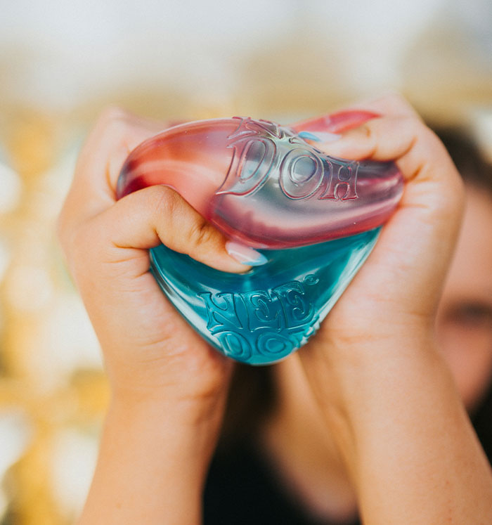 Two hands squeezing colorful squishy toys, one red and one blue, featuring the popular squishy toys. Two hands squeezing colorful squishy toys, one red and one blue, featuring the popular squishy toys.