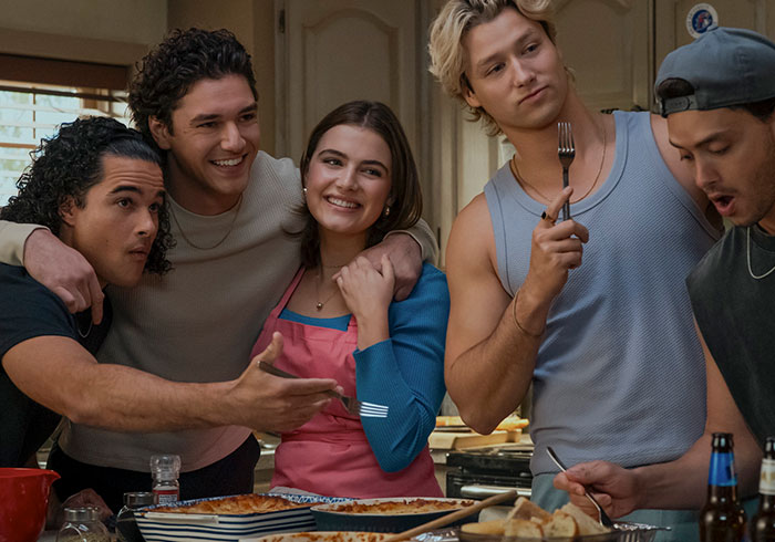 A group of friends laughing in a kitchen, representing a scene from the cancelled female-centric show.