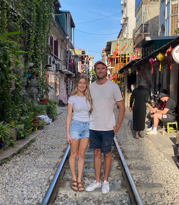 Couple standing on railroad tracks enjoying outdoor moment representing star athlete's wife