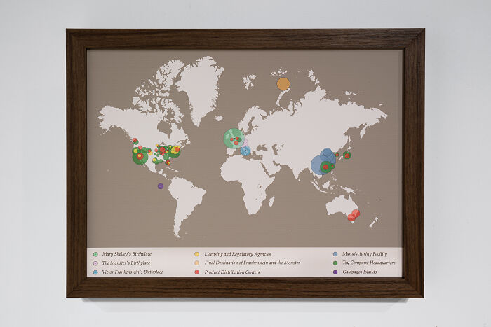 A framed map of the world with colorful data visualization circles resembling unusual sculptures data