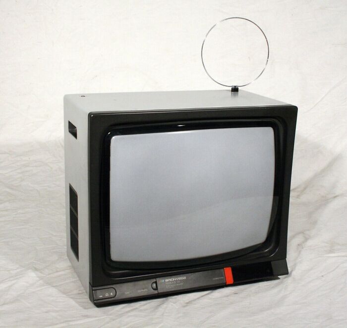 A small, portable television set with a circular antenna, highlighting retro tech from the 80s.