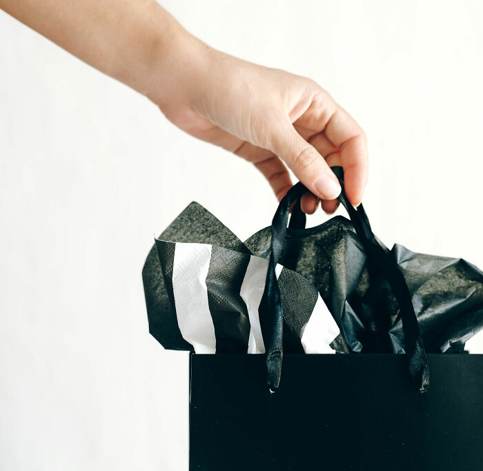 A hand holds a shopping bag, potentially signaling a promising start to a first date.