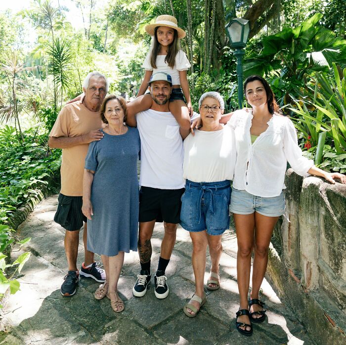A multi-generational family stands together outdoors; going no contact with a parent can be a difficult decision.