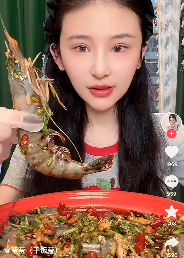 A mukbang star eats a large shrimp with spicy sauce, revealing a dangerous condition linked to extreme eating.