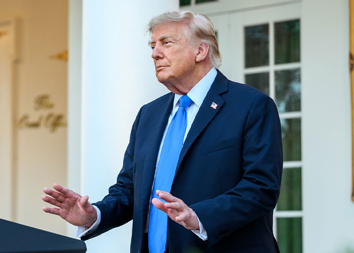 Trump at a podium, speaking. White House responds to viral image showing Trump and Natalie Harp.