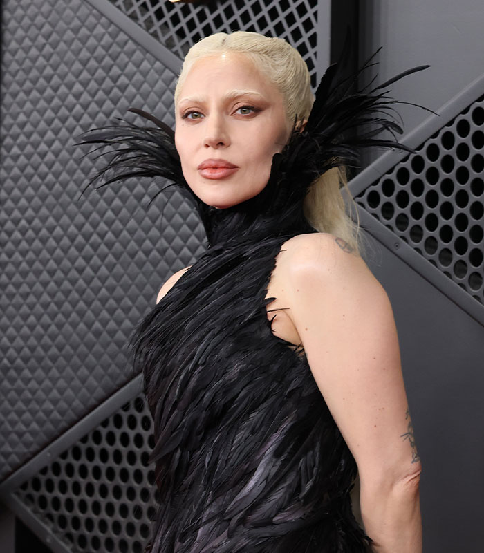 Lady Gaga in a black feathered dress, facing criticism over her baby girl's name.