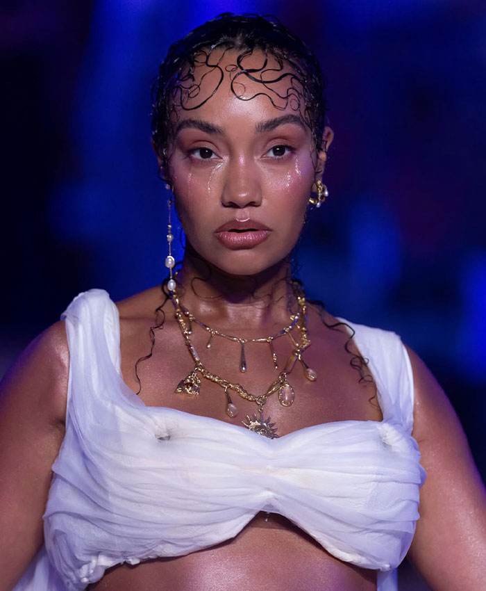 Pregnant star Leigh-Anne Pinnock close-up with wet-look hair and gold jewelry on the runway.