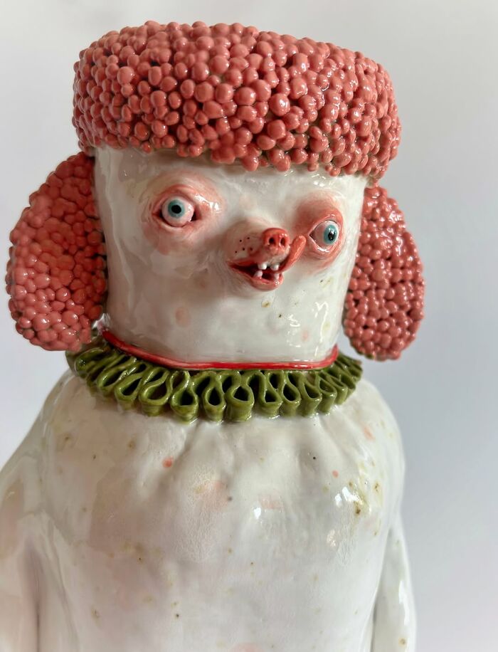 Close-up of a whimsical pink poodle ceramic sculpture with googly eyes, perfect as quirky home decor.