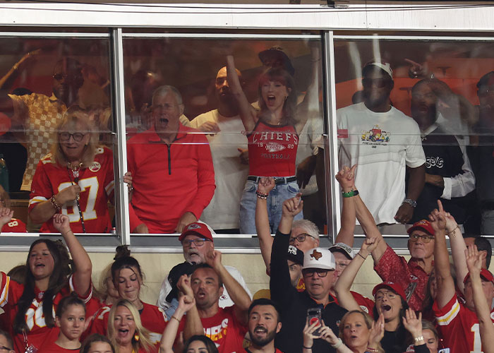 Taylor Swift celebrating inside a VIP suite at a Chiefs game next to fans Taylor Swift celebrating inside a VIP suite at a Chiefs game next to fans