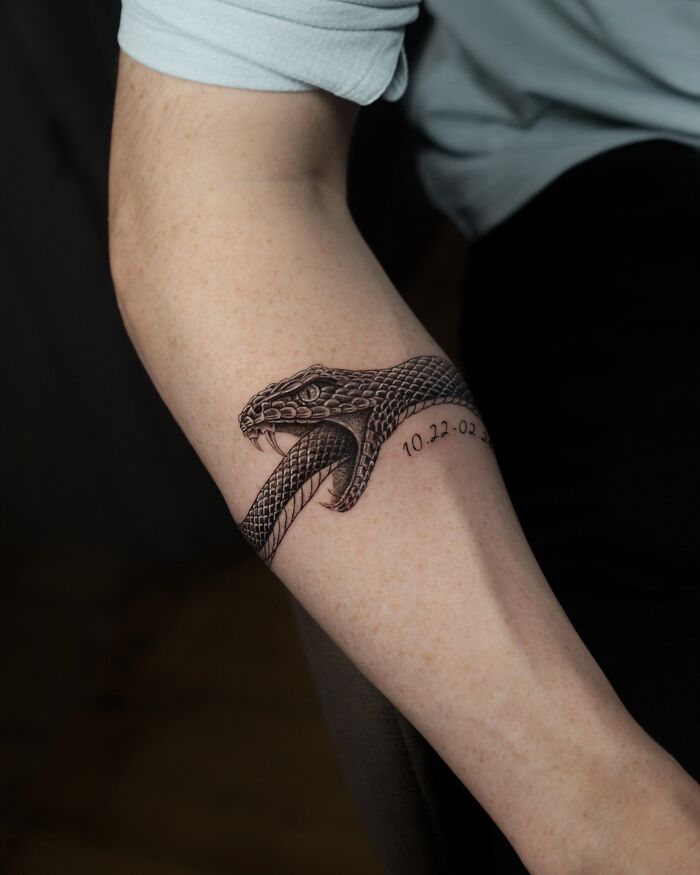 Snake tattoo with detailed scales nature ink on forearm