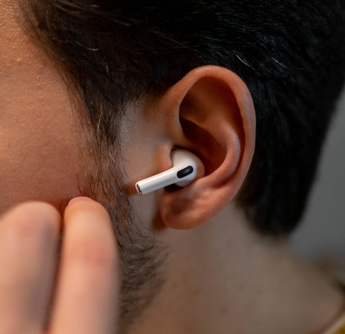 Close up of person wearing wireless earbuds during vacation