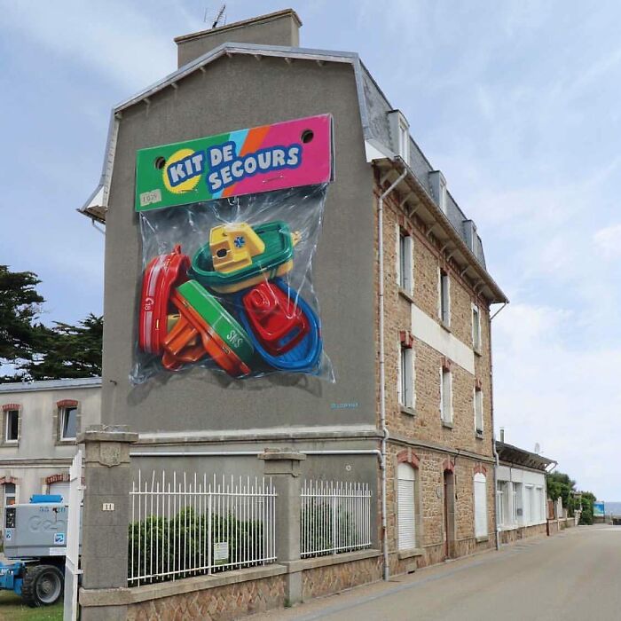 An entire building transformed into a giant package of colorful street art toys, making a bold statement.