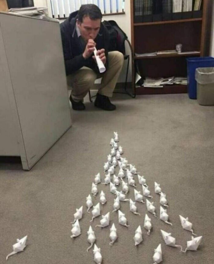 A man with unhinged images of paper mice coming out of a flute, creating an unusual scene.