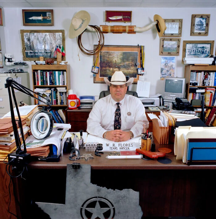 A photographer's project documenting a Texas Ranger behind a busy desk, showcasing the people and offices of bureaucracy.