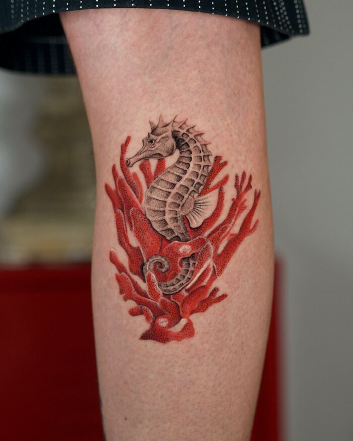 Seahorse tattoo with red coral nature ink design on leg