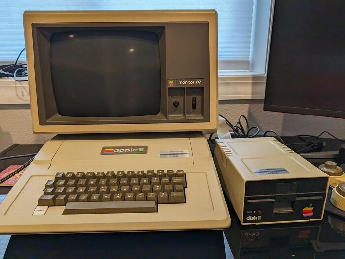 An Apple II personal computer with a monitor and Disk II drive, a classic example of '80s retro tech.