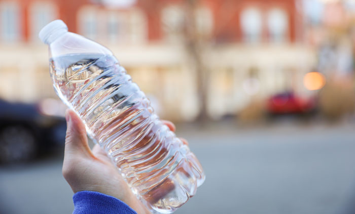 A person holding a bottle of water, symbolizing crazy things women do for a crush.