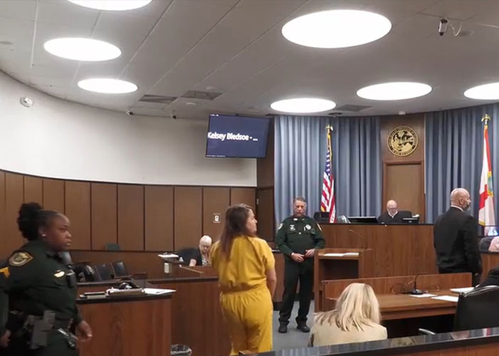Courtroom scene with a woman in a yellow jumpsuit. The children's mother is identified as the attacker. Courtroom scene with a woman in a yellow jumpsuit. The children's mother is identified as the attacker.