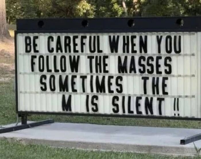 A silly-funny-sign on a marquee says, Be careful when you follow the masses, sometimes the M is silent.