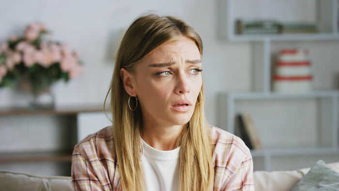 A concerned woman looking away, representing dumb ways people ruin their lives.