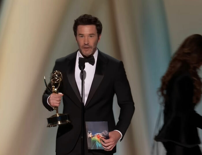 A star at the Emmy presentation holding an award, with a joke met with silent stares. A star at the Emmy presentation holding an award, with a joke met with silent stares.