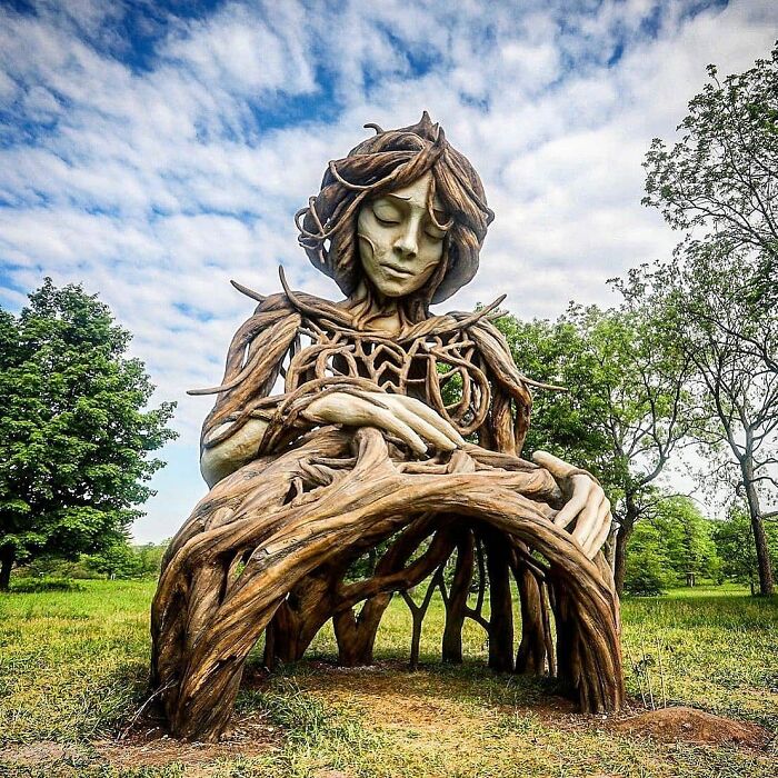 Tree root sculpture of a woman, an example of stunning street art making streets real museums.