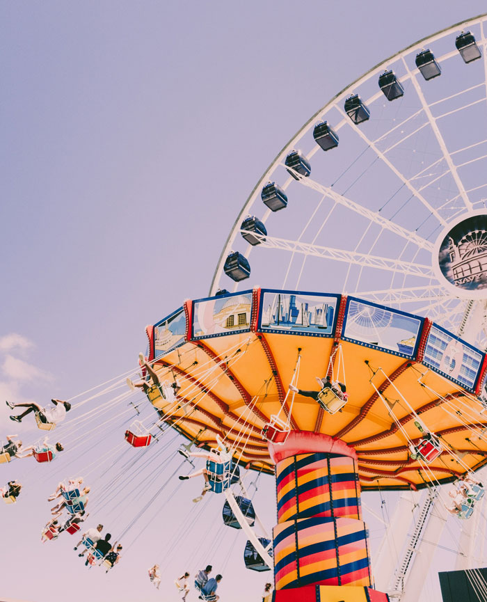 A colorful fairground ride with people, contrasting the lightheartedness with the potential relationships and headaches.